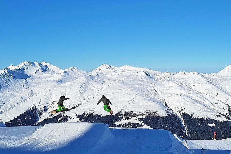 Two snowboarders captured getting air in the snow park - Winter Davos Ski Resort Switzerland