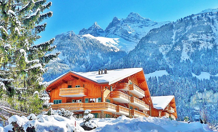 The Lodge covered in snow with Snow covered mountains in the background