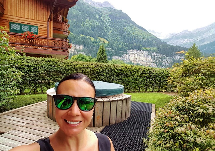 Mel in front of hot tub showing the mountain views